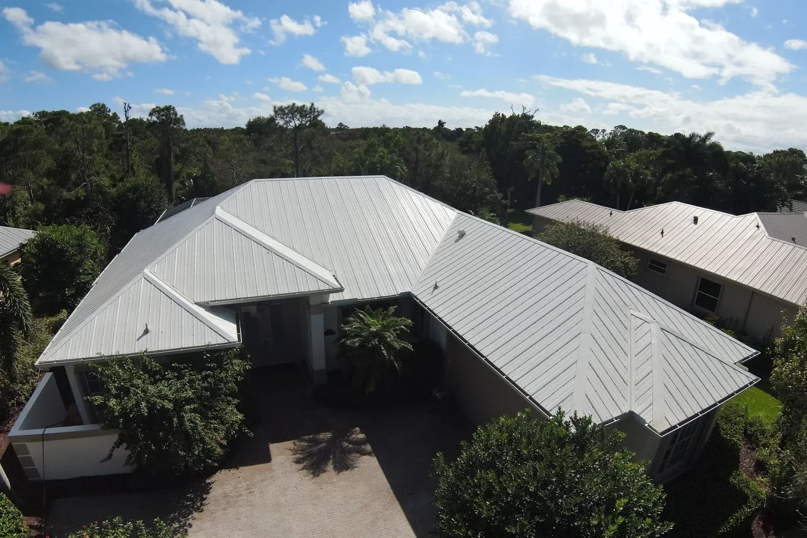 Freshly soft-washed metal roof on a South Florida home, gleaming under a clear blue sky